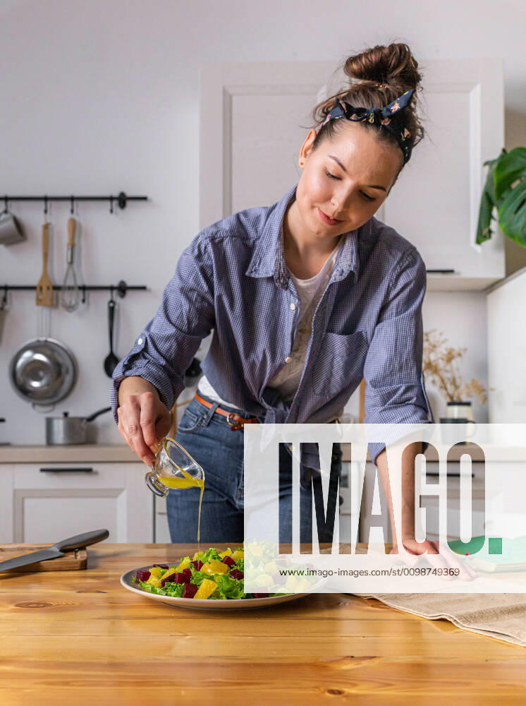 Young and beautiful housewife woman cooking in a white kitchen Krasnodar, Krasnodar Krai, Russia ,model released, Symbolfoto CR_EVUV200313-320691-01