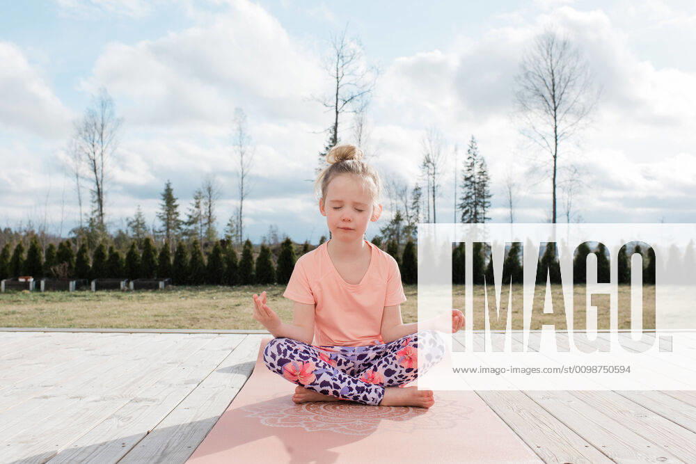 Young girl meditating doing yoga in her back yard at home Norrto¤lje, Stockholm County, Sweden ,model released, Symbolfoto CR_RABE200318-320959-01