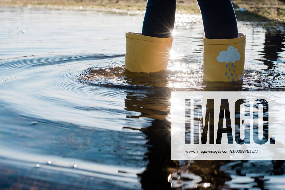 Kids rain boots in a big puddle of water at sunset NorrtoÂ¤lje, Stockholm County, Sweden ,model released, Symbolfoto CR_RABE200320-317752-01