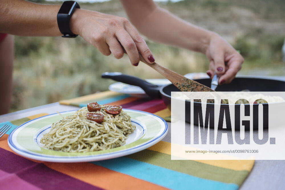 Close up of woman s hands preparing pasta with pesto during a trip. BooÂ, CT, Spain ,model released, Symbolfoto CR_SCLO200323B-320057-01
