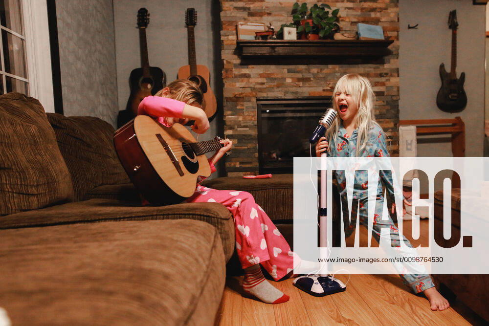 IMAGO Creative: Digitale Welt, Verzicht auf Technologie Young girls singing loudly and playing guitar in living room Windsor, ON, Canada ,model released, Symbolfoto CR_JEOH200327-323897-01