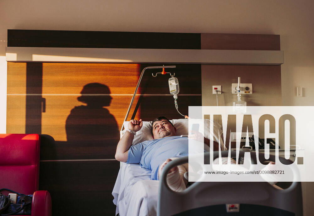 Patient lying in hospital bed with silhouette of a woman behind curtain model released Symbolfoto property released LJF01351