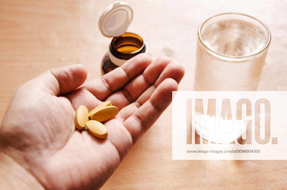 Pills in a hand Pills spilling from a bottle into a hand.