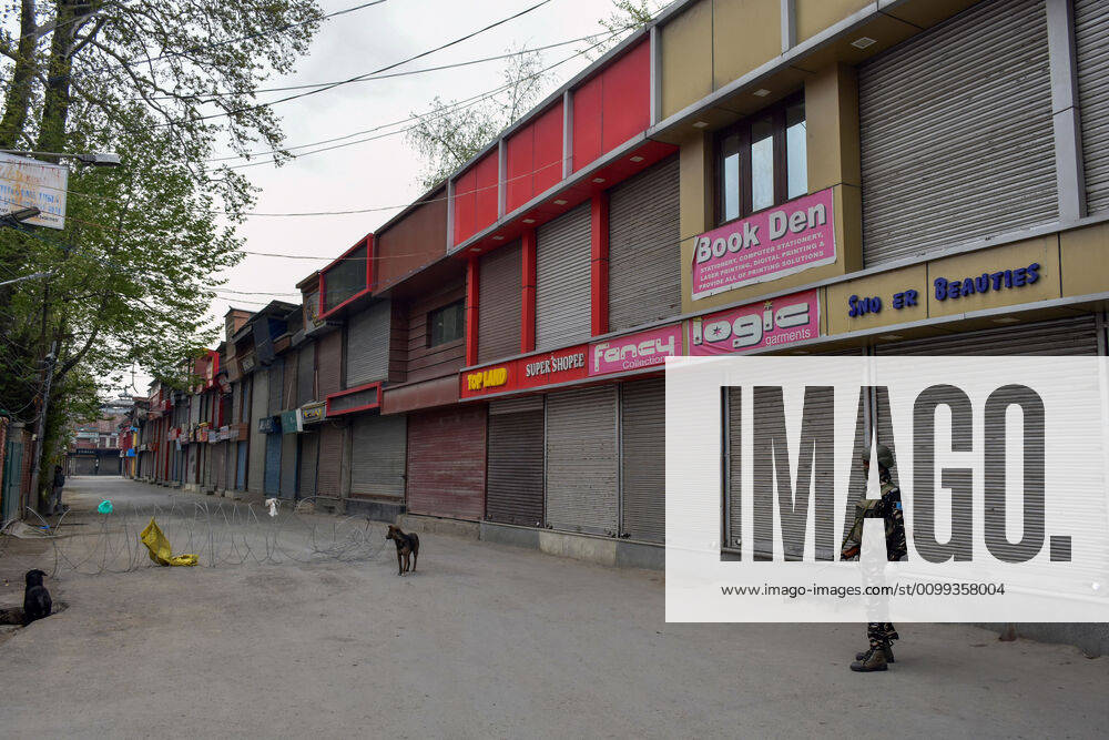Srinagar, Jammu & Kashmir, India: A paramilitary trooper stands on guard in front of closed shops during a nationwide lockdown imposed to prevent the spread of coronavirus in Srinagar..Jammu and Kashmir has confirmed 235 coronavirus cases, 4 deaths and 6 recovered cases. Srinagar India - ZUMAs197 20200413_zaa_s197_022