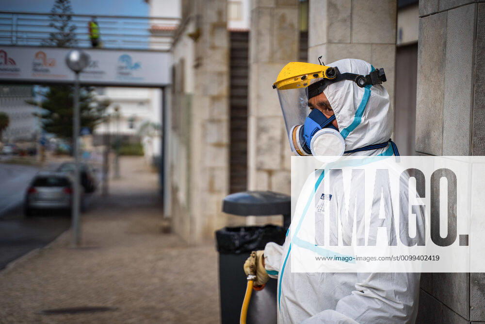 An employee of the Ericeira parish council, equipped with the recommended protective materials, disinfects the street with a solution based on hypochlorite (bleach)..The municipality of Mafra had 70 cases of COVID-19 pandemic. In order to prevent the spread of the virus, the Ericeira Parish Council perform weekly street disinfection. Ericeira Portugal - ZUMAs197 20200414_zaa_s197_168