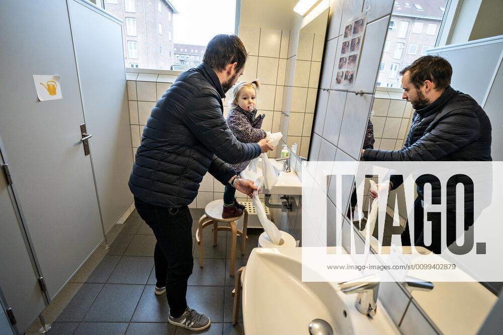 The nursery DUI in Aalborg opens again for the institutions children, Wednesday morning, April 15, 2020 Solvej wash hands with his father Due to the corona crisis, the nursery has been closed, and after the nursery has been changed inside and outside the children and the adult educators can hold distance and washing hands, Aalborg Jutland Denmark,