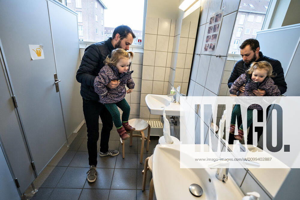 The nursery DUI in Aalborg opens again for the institutions children, Wednesday morning, April 15, 2020 Solvej wash hands with his father Due to the corona crisis, the nursery has been closed, and after the nursery has been changed inside and outside the children and the adult educators can hold distance and washing hands, Aalborg Jutland Denmark,