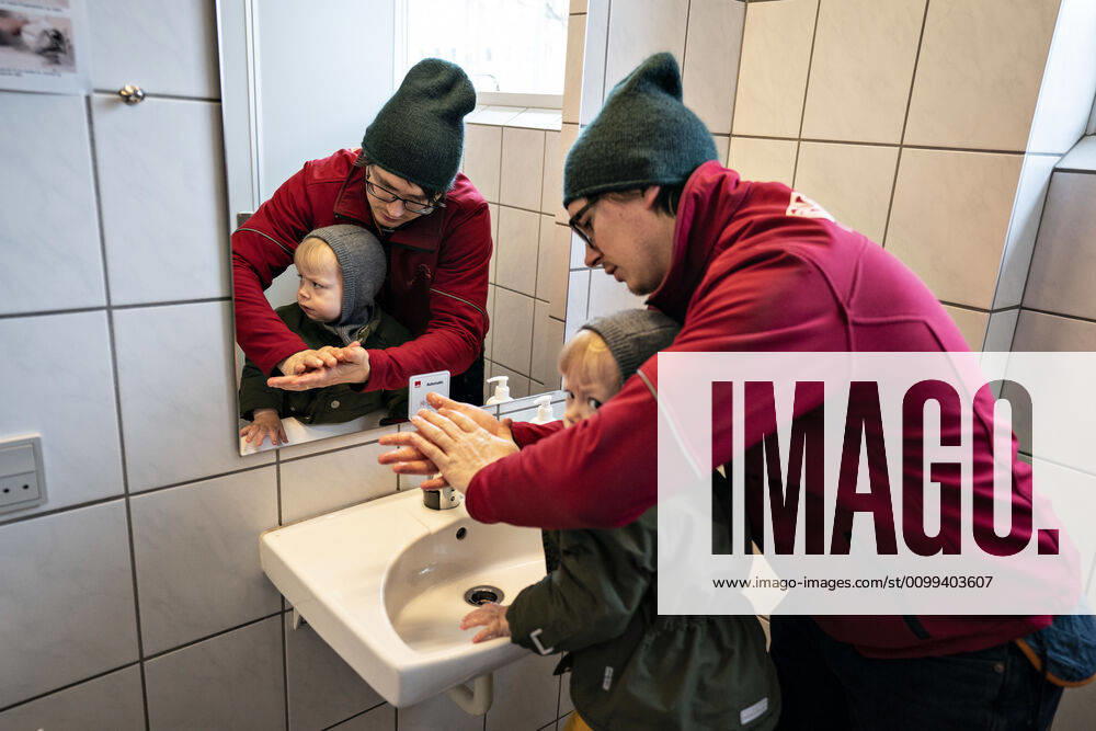 The nursery DUI in Aalborg opens again for the institutions children, Wednesday morning, April 15, 2020 Here, Aksel and his father wash their hands as the first on arrival Due to the corona crisis, the nursery has been closed and after the nursery has been changed inside and outside the children can and the adult educators keep away and wash hands, Aalborg Jutland Denmark,