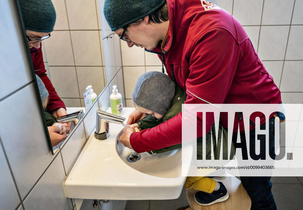 The nursery DUI in Aalborg opens again for the institutions children, Wednesday morning, April 15, 2020 Here, Aksel and his father wash their hands as the first on arrival Due to the corona crisis, the nursery has been closed and after the nursery has been changed inside and outside the children can and the adult educators keep away and wash hands, Aalborg Jutland Denmark,