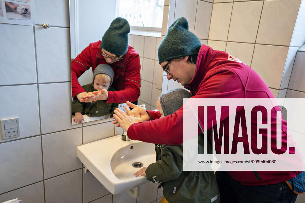 The nursery DUI in Aalborg opens again for the institutions children, Wednesday morning, April 15, 2020 Here, Aksel and his father wash their hands as the first on arrival Due to the corona crisis, the nursery has been closed and after the nursery has been changed inside and outside the children can and the adult educators keep distance and wash hands, Aalborg Jutland,