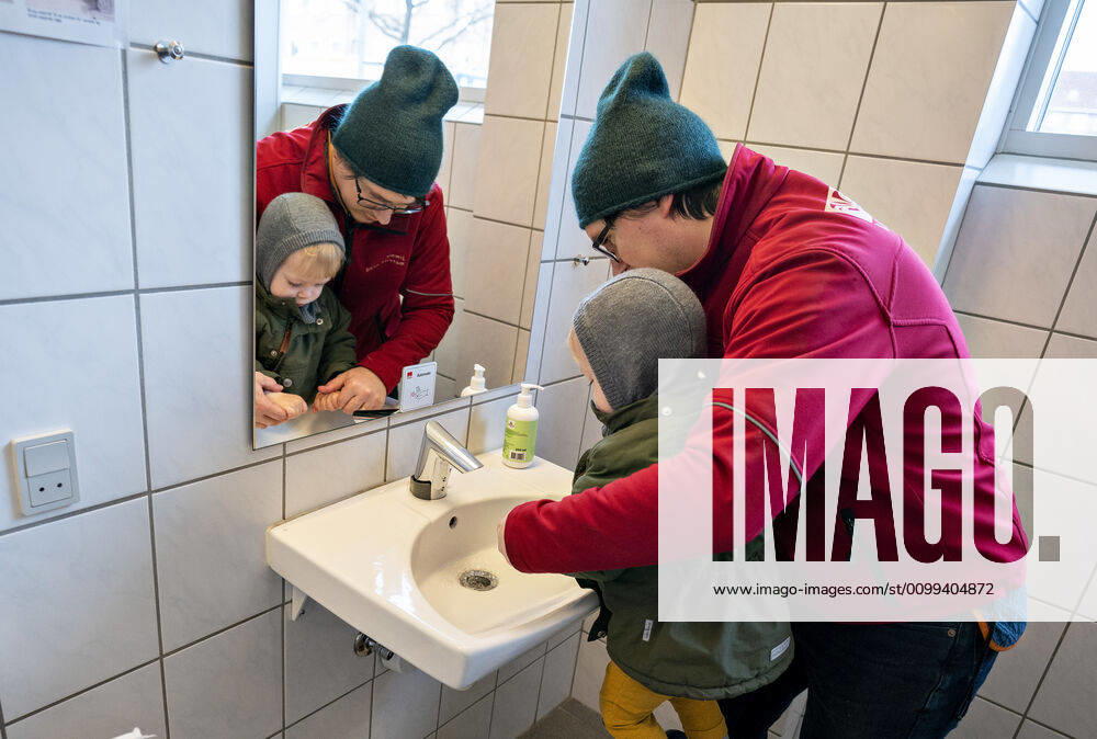 The nursery DUI in Aalborg opens again for the institutions children, Wednesday morning, April 15, 2020 Here, Aksel and his father wash their hands as the first on arrival Due to the corona crisis, the nursery has been closed and after the nursery has been changed inside and outside the children can and the adult educators keep away and wash hands, Aalborg Jutland Denmark,