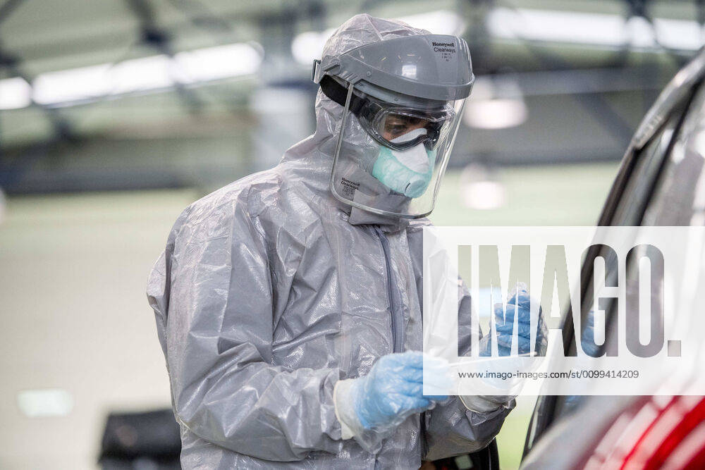 A health worker in a protective suit takes a sample for a PCR test..During the coronavirus crisis, at the ITV (technical inspection of vehicles) center in Albolote PCR tests (polymerase chain reaction) are carried out on workers of the security forces and staff of nursing homes to detect Covid 19. Granada Spain - ZUMAs197 20200415_zaa_s197_097