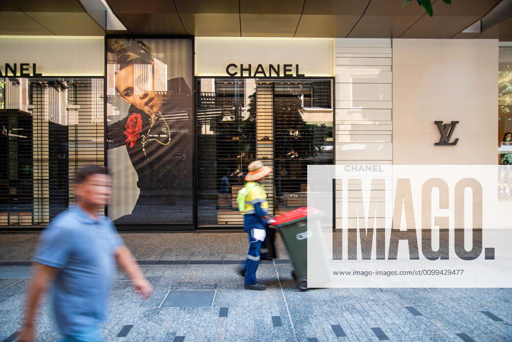 A pedestrian and a council worker walking in front of shut luxury shops during Coronavirus crisis..Australian states including Queensland take strict new lockdown rules to stop the spread of Covid-19. Queensland Australia - ZUMAs197 20200416_zaa_s197_012
