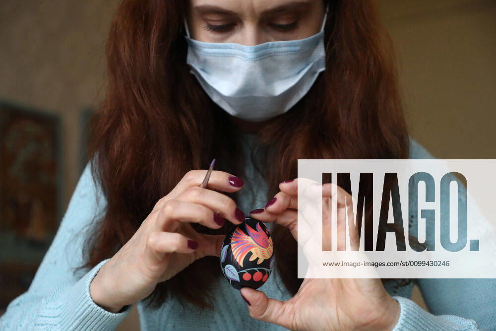 Artist Iya Tokareva in a face mask paints a wooden Easter egg Gorodets-style at her home studio; Gorodets painting, one of the traditional Russians handicrafts, originated in the middle of XIX century in the town of Gorodets, the Nizhny Novgorod Region. Anton Novoderezhkin TASS TS0D5FDD