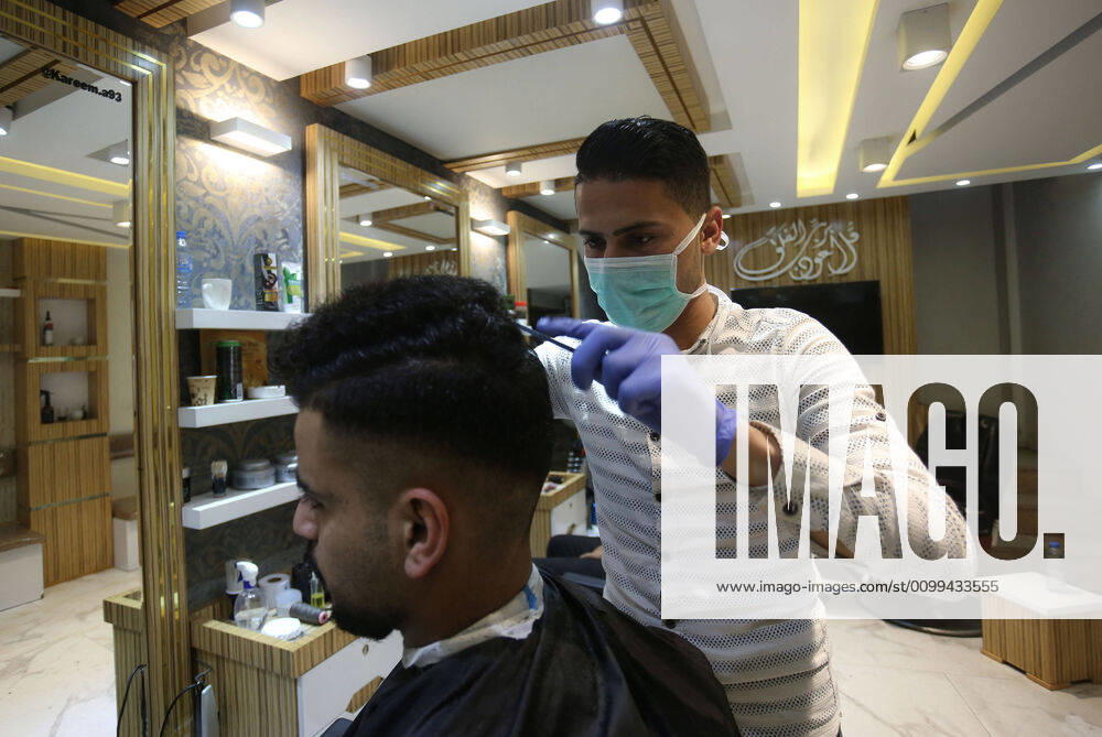 Daily Life at Barber in Southern Gaza Strip, Palestine amid Coronavirus Outbreak - 16 April 2020. A Palestinian barber wearing a face mask and a medical glove with his hand as a precautionary measure against Coronavirus (COVID-19), sterilizes his tools before cutting the customer s hair in Khan Yunis, southern Gaza Strip, Palestine, April 16, 2020. (Photo by Yousef Masoud INA Photo Agency imago images)