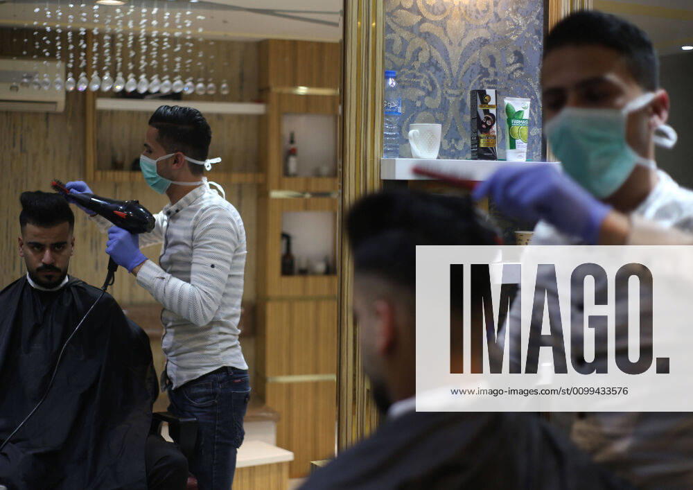 Daily Life at Barber in Southern Gaza Strip, Palestine amid Coronavirus Outbreak - 16 April 2020. A Palestinian barber wearing a face mask and a medical glove with his hand as a precautionary measure against Coronavirus (COVID-19), sterilizes his tools before cutting the customer s hair in Khan Yunis, southern Gaza Strip, Palestine, April 16, 2020. (Photo by Yousef Masoud INA Photo Agency imago images)