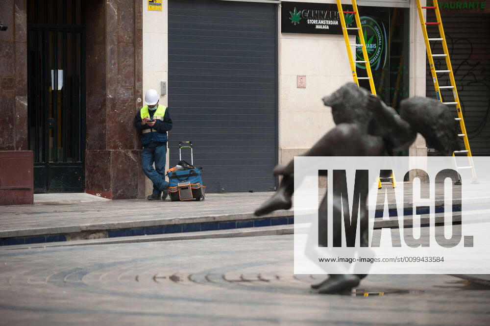 A construction worker resting at an empty street during the covid-19 crisis..Following the confinement decreed by the Spanish government and will extended until 10th May, people are confinement in their homes causing an exceptional situation of unusual urban scenes such as empty streets. Malaga Spain - ZUMAs197 20200416_zaa_s197_051