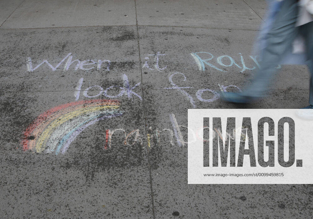 A healthcare worker walks by an uplifting message written in colored chalk on the sidewalk of NYU Langone hospital moments before FDNY firefighters, NYPD police officers and pedestrians applaud and show their gratitude to medical staff and essential workers on the front lines of the coronavirus pandemic in New York City on Friday, April 17, 2020. The city s coronavirus death toll continued to climb with over 700 new COVID-19 fatalities bringing the total to over 12,000 to date. NYP20200417114 JOHNxANGELILLO