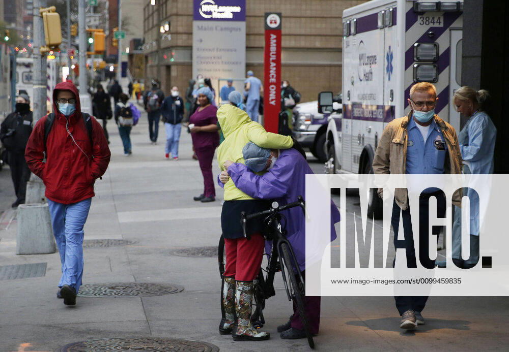 A healthcare worker embraces a lady on a bicycle outside of NYU Langone hospital when FDNY firefighters, NYPD police officers and pedestrians applaud and show their gratitude to medical staff and essential workers on the front lines of the coronavirus pandemic in New York City on on Friday, April 17, 2020. The city s coronavirus death toll continued to climb with over 700 new COVID-19 fatalities bringing the total to over 12,000 to date. NYP20200417111 JOHNxANGELILLO
