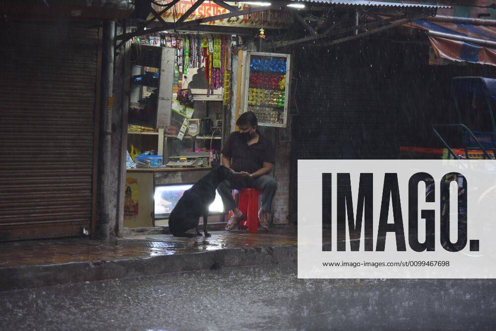 A man and a dog outside a shop while it rains heavily near Pandav Nagar during lockdown, on April 18, 2020 in New Delhi, India. (Photo by Raj K Raj Hindustan Times ) Heavy Rainfall In Delhi-NCR