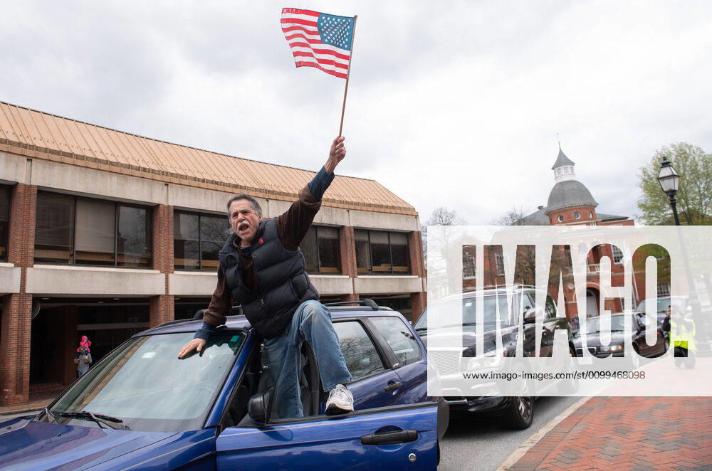 A man yells from the door of his vehicle during a car protest to reopen Maryland and end the stay at home order imposed during the Coronavirus COVID-19 pandemic, near the state capitol building in Annapolis, Maryland on Saturday, April 18, 2020. Drivers circled Annapolis hoking their horns and calling for Gov. Larry Hogan (R-MD) to end the stay at home order. WAP20200418332 KEVINxDIETSCH