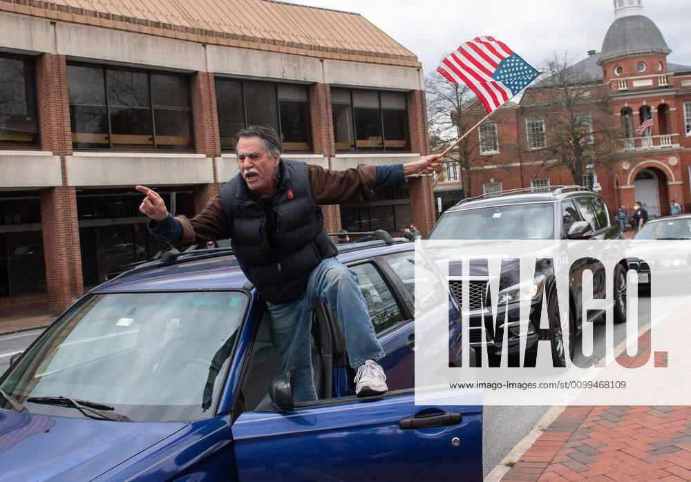 A man yells from the door of his vehicle during a car protest to reopen Maryland and end the stay at home order imposed during the Coronavirus COVID-19 pandemic, near the state capitol building in Annapolis, Maryland on Saturday, April 18, 2020. Drivers circled Annapolis hoking their horns and calling for Gov. Larry Hogan (R-MD) to end the stay at home order. WAP20200418338 KEVINxDIETSCH