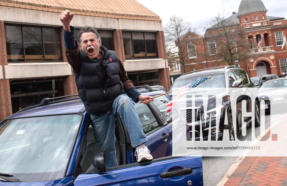 A man yells from the door of his vehicle during a car protest to reopen Maryland and end the stay at home order imposed during the Coronavirus COVID-19 pandemic, near the state capitol building in Annapolis, Maryland on Saturday, April 18, 2020. Drivers circled Annapolis hoking their horns and calling for Gov. Larry Hogan (R-MD) to end the stay at home order. WAP20200418342 KEVINxDIETSCH