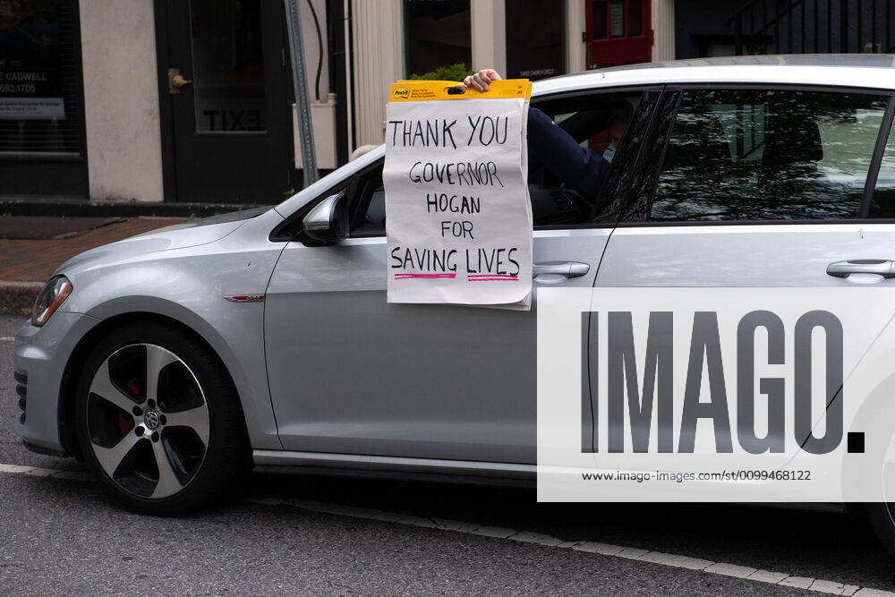 A counter protester holding a pro Gof. Hogan sign drives in a protest to reopen Maryland and end the stay at home order imposed during the Coronavirus COVID-19 pandemic, near the state capitol building in Annapolis, Maryland on Saturday, April 18, 2020. Drivers circled Annapolis hoking their horns and calling for Gov. Larry Hogan (R-MD) to end the stay at home order. WAP20200418354 KEVINxDIETSCH