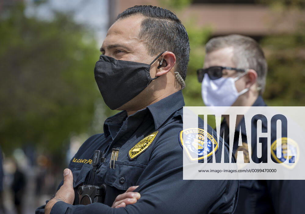 San Diego police watch from across the street as protesters at a Liberate San Diego rally in downtown San Diego on Saturday waved signs and held banners complaining that they wanted the state to lift its stay at home order, a measure meant to reduce the spread of the coronavirus. The event was clearly political, with an overwhelming amount of signs and banners supporting President Trump. San Diego US - ZUMAp23_ 20200418_zaf_p23_019