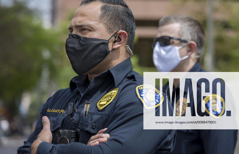 San Diego police watch from across the street as protesters at a Liberate San Diego rally in downtown San Diego on Saturday waved signs and held banners complaining that they wanted the state to lift its stay at home order, a measure meant to reduce the spread of the coronavirus. The event was clearly political, with an overwhelming amount of signs and banners supporting President Trump. San Diego US - ZUMAp23_ 20200418_zaf_p23_020