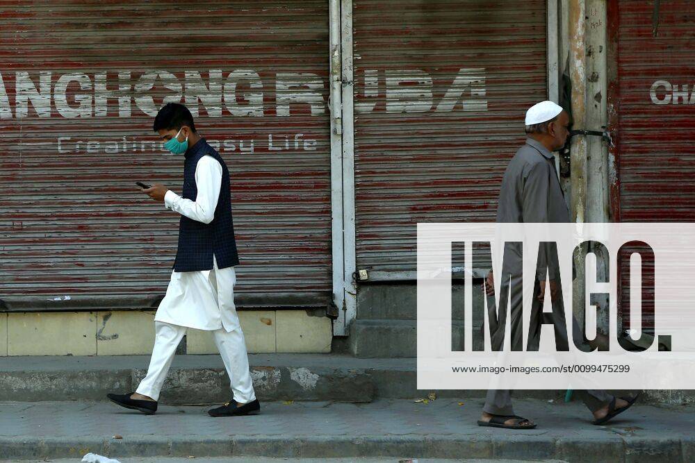(200419) -- RAWALPINDI, April 19, 2020 -- People walk past a closed shop in Rawalpindi of eastern Pakistan s Punjab province on April 19, 2020. ) PAKISTAN-RAWALPINDI-COVID-19-DAILY LIFE AhmadxKamal