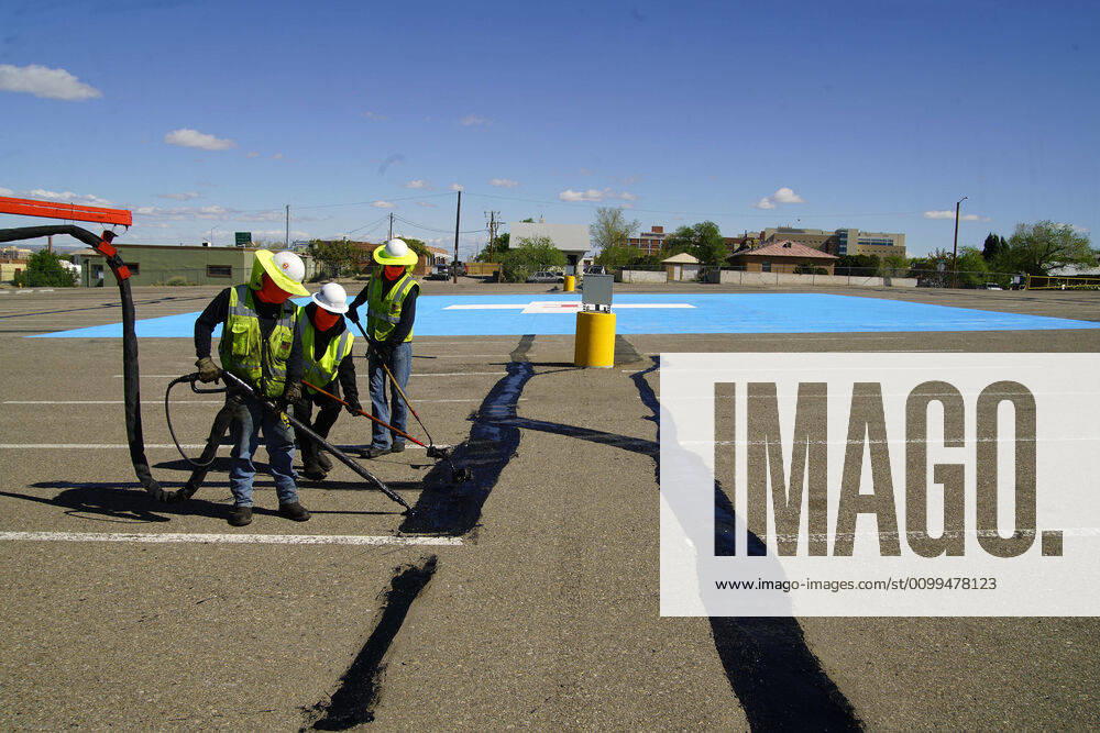 041920 ..A Sunland Asphalt crew seals cracks in the parking lot of Milne Stadium in Southeast Albuquerque. The site will be used as a Heliport to transport Covid- 19 patients to Presbyterian Hospital..Photographed on Sunday April 19, 2020.Adolphe Pierre-LouisJournal. Albuquerque USA - ZUMAab1_ 20200419_zaf_ab1_004