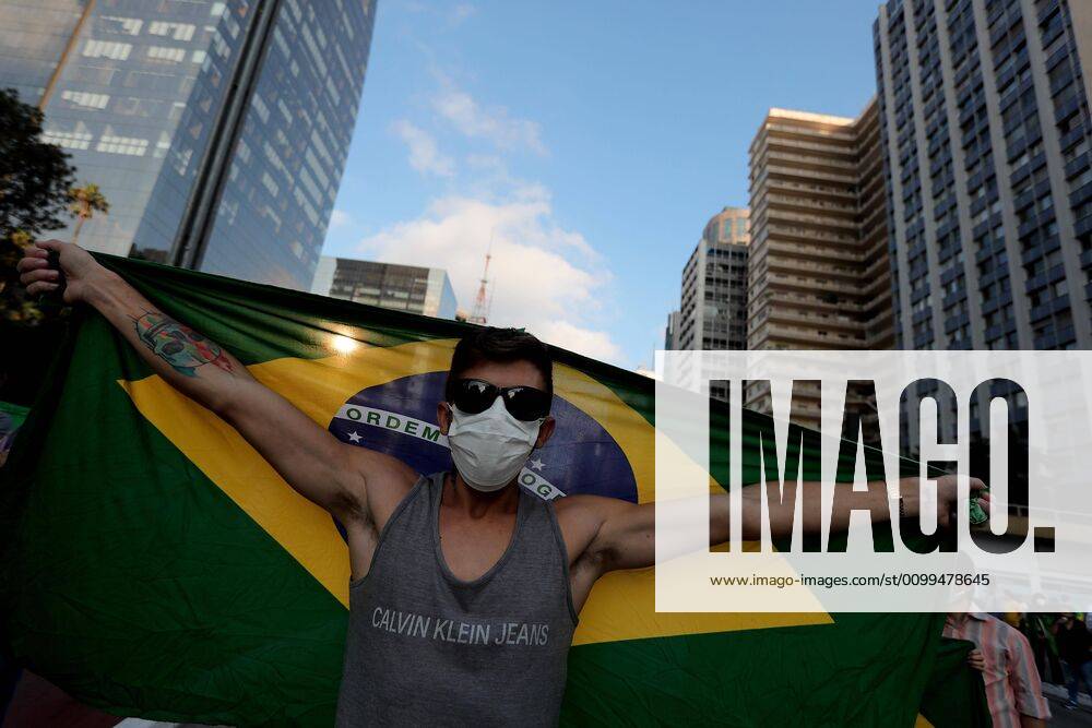 A man with a facial mask waves a Brazilian flag during a demonstration against social isolation and in favor of military intervention, on Paulista Avenue, in Sao Paulo, Brazil, 19 April 2020. The President of Brazil, Jair Bolsonaro, once again ignored the health recommendations for social distancing amid the coronavirus pandemic and took part this Sunday in one of the several demonstrations that were held in his favor in different cities of the country. Bolsonaro spoke in Brasilia before hundreds of sympathizers who gathered outside the Army Headquarters to request a military intervention. Bolsonaro ignores recommendations and takes part in a day of demonstrations !ACHTUNG: NUR REDAKTIONELLE NUTZUNG!