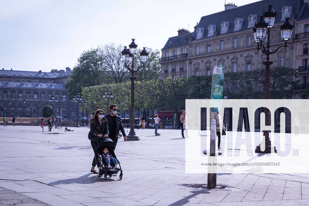 A couple with their child wearing face masks walk along the forecourt of Paris City Hall during the quarantine..France has recorded 112606 confirmed cases, 36578 recovered and 19718 deaths by the corona virus. Paris France - ZUMAs197 20200419_zaa_s197_088
