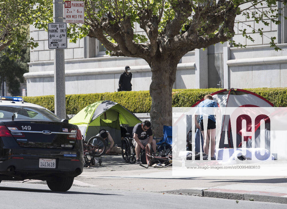Police pass a homeless encampment in the civic center in San Francisco on Sunday, April 19, 2020. San Francisco Mayor London Breed says that efective now, face masks must be worn outside the home to protect against coronavirus. SXP2020041904 TERRYxSCHMITT