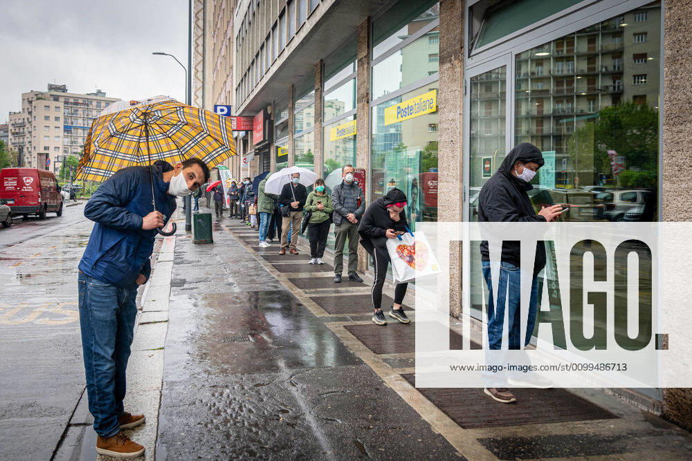 Milan - Long queue in the rain at the post office in viale Andrea Doria at the time of the coronavirus (Marco Passaro Fotogramma, Milan - 2020-04-20) p.s. la foto e utilizzabile nel rispetto del contesto in cui e stata scattata, e senza intento diffamatorio del decoro delle persone rappresentate