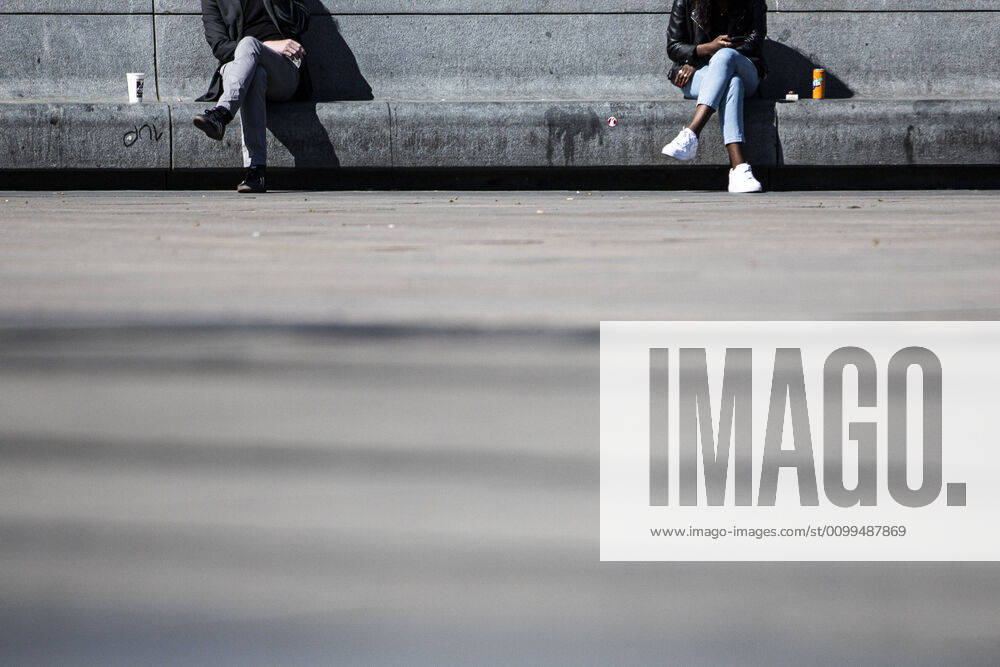 Two people sitting on a stone bench at a distance, taken in Berlin, 20 04 2020 Due to the spread of the coronavirus there are contact restrictions throughout Germany Berlin Germany
