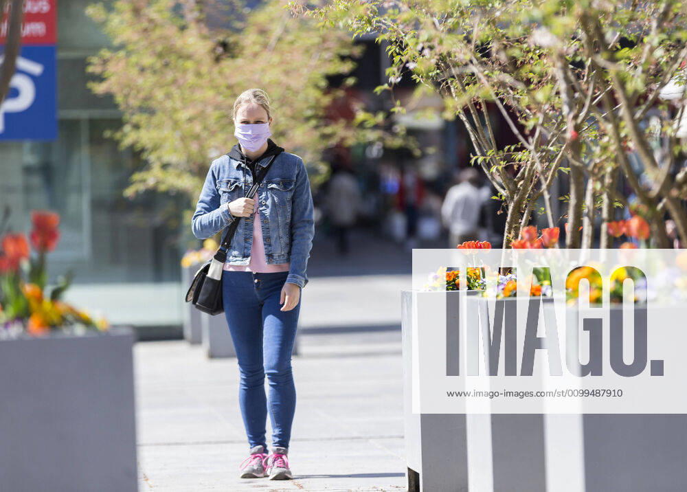 Germany, , , , 20 04 2020, Presse, COVID 19 Germany is slowly rising again Bild In Hesse, shops have reopened, in Bavaria they havent. This has a particular effect on the East Hessian city of Fulda, which is not far from the Bavarian border A woman walks through Fulda wearing a face mask