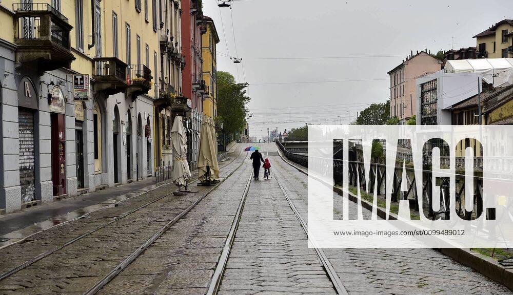 Milan, deserted city due to bad weather and the disposition for coronavirus, in the photo father with son on the Naviglio Grande (Duilio Piaggesi Fotogramma, Milan - 2020-04-20) p.s. la foto e utilizzabile nel rispetto del contesto in cui e stata scattata, e senza intento diffamatorio del decoro delle persone rappresentate