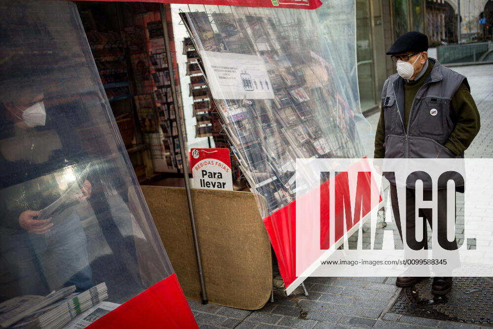 A man wearing a protective face mask waits for buying a newspaper in a kiosk in Barcelona. Spain will begin deescalation of coronavirus measures without knowing the incidence of the epidemic, coronavirus deaths stabilize with 435 in the past 24 hours. Barcelona Spain - ZUMAb137 20200422_zap_b137_008