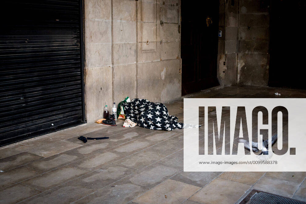 Early in the morning a homeless man sleeps under a blanket at the empty porches of Barcelona s Placa Reial square during lockdown. Spain will begin deescalation of coronavirus measures without knowing the incidence of the epidemic, coronavirus deaths stabilize with 435 in the past 24 hours. Barcelona Spain - ZUMAb137 20200422_zap_b137_016