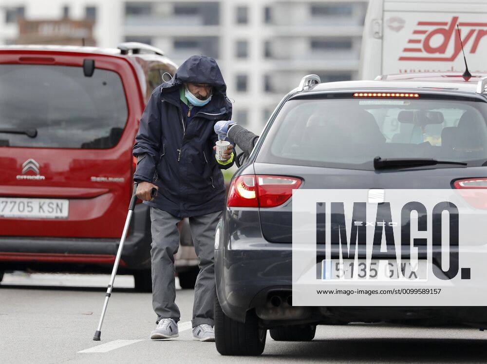 A homeless, protected with a mask, begs among the cars stopped at Cerda square in Barcelona, Spain, 22 April 2020. Spain is under a lockdown to avoid the spreading of pandemic of the COVID-19 disease caused by the SARS-CoV-2 coronavirus. Daily life during lockdown !ACHTUNG: NUR REDAKTIONELLE NUTZUNG!