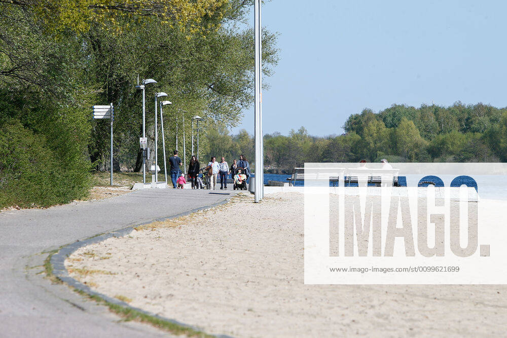 Consequences of the Corona Virus in Wolfsburg, Passers-by on the paths along the Allersee People are using the banks of the Allersee again to relax, go for a walk or do sports After a ban on entering the lake in recent weeks, this ban has now been lifted, but sunbathing or using the games and sports grounds is still prohibited Wolfsburg