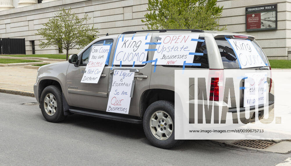 NY: Operation Gridlock in Albany Car plastered with posters seen during Operation Gridlock protest outside of New York State Capitol Building. Participants demanded reopening of New York State. Many people on the street disregarded wearing facial masks and keep social distances. Albany New York United States