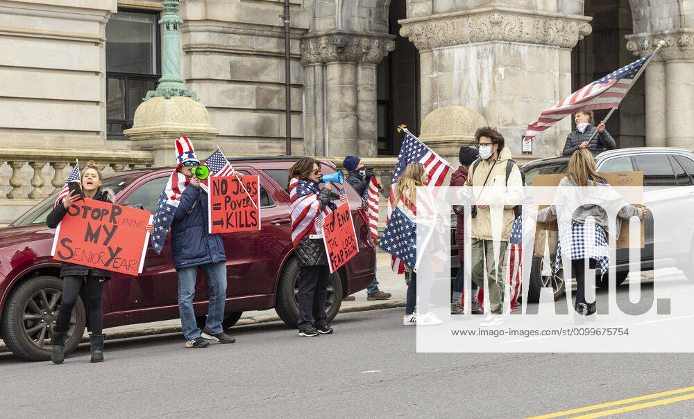 NY: Operation Gridlock in Albany People in cars and on streets with American flags and Trump flags participate in Operation Gridlock protest outside of New York State Capitol Building. Participants demanded reopening of New York State. Many people on the street disregarded wearing facial masks and keep social distances. Albany New York United States