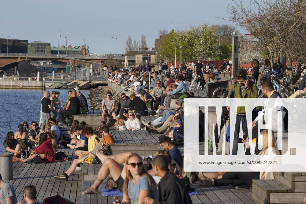 Copenhageners enjoy the warm spring weather at Island Brygge in Copenhagen on Thursday, April 23, 2020 NOTE the picture a recorded with a telephoto lens and the distance between people in the picture can be perceived less than it really is , Copenhagen Denmark,