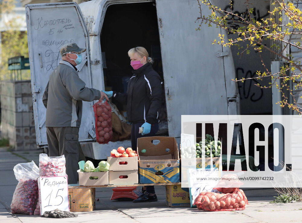 Coronavirus in der Ukraine, Eindrücke aus Kiew KYIV, UKRAINE - APRIL 23, 2020 - A man in a face mask buys a sack of potatoes from a street vendor during the quarantine, Kyiv, capital of Ukraine. Daily life of Kyiv during quarantine on April 23, 2020
