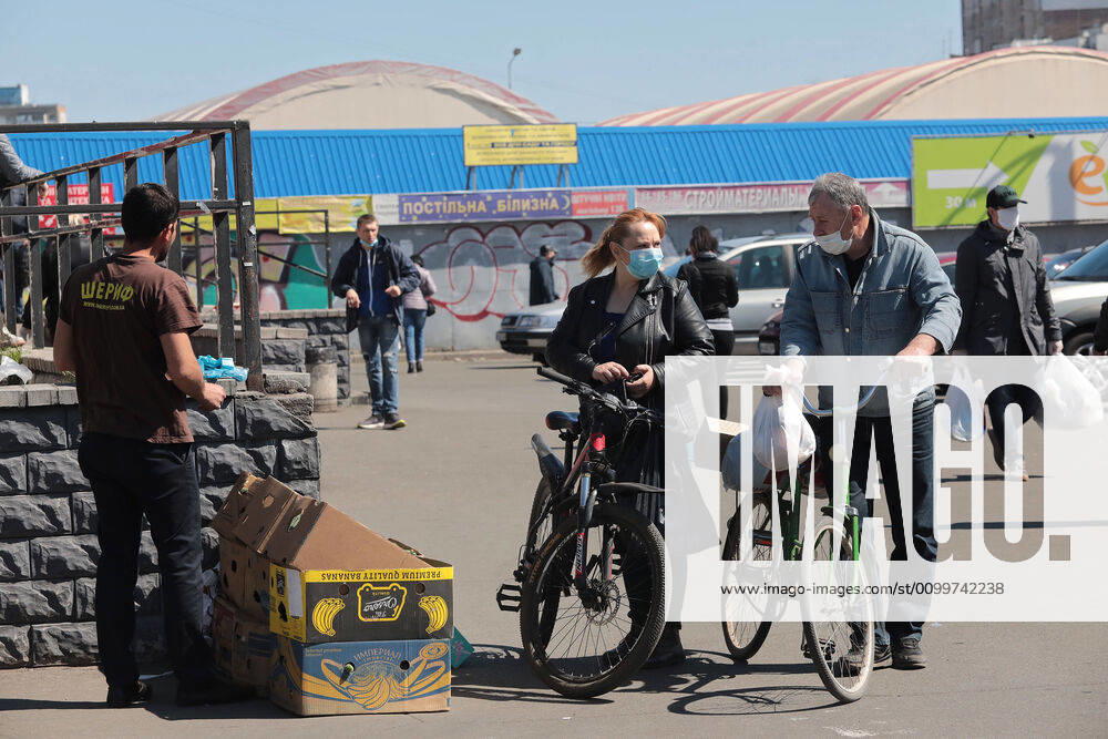 Coronavirus in der Ukraine, Eindrücke aus Kiew KYIV, UKRAINE - APRIL 23, 2020 - A man and a woman in face mask shop at a street market during the quarantine, Kyiv, capital of Ukraine. Daily life of Kyiv during quarantine on April 23, 2020