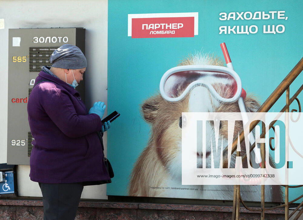 Coronavirus in der Ukraine, Eindrücke aus Kiew KYIV, UKRAINE - APRIL 23, 2020 - A woman wearing gloves browses her phone during the quarantine, Kyiv, capital of Ukraine. Daily life of Kyiv during quarantine on April 23, 2020