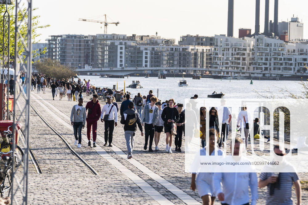 Copenhageners enjoy the warm spring weather at Island Brygge in Copenhagen on Thursday, April 23, 2020 NOTE the picture taken with a telephoto lens and the distance between people in the picture can be perceived less than it really is , Denmark,